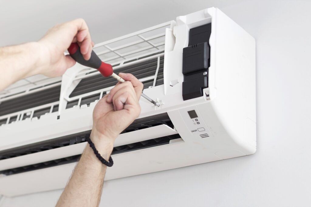 Technician from an air conditioning installation company repairing a wall-mounted air conditioner.